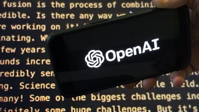 The OpenAI logo appears on a mobile phone in front of a screen showing a portion of the company website in this photo taken on Tuesday, Nov. 21, 2023 in New York. (AP Photo/Peter Morgan)