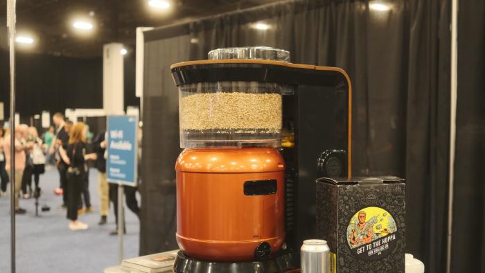 An Exobrew sitting on a messy table at CES Unveiled 2024 next to Get to the Hoppa beer.